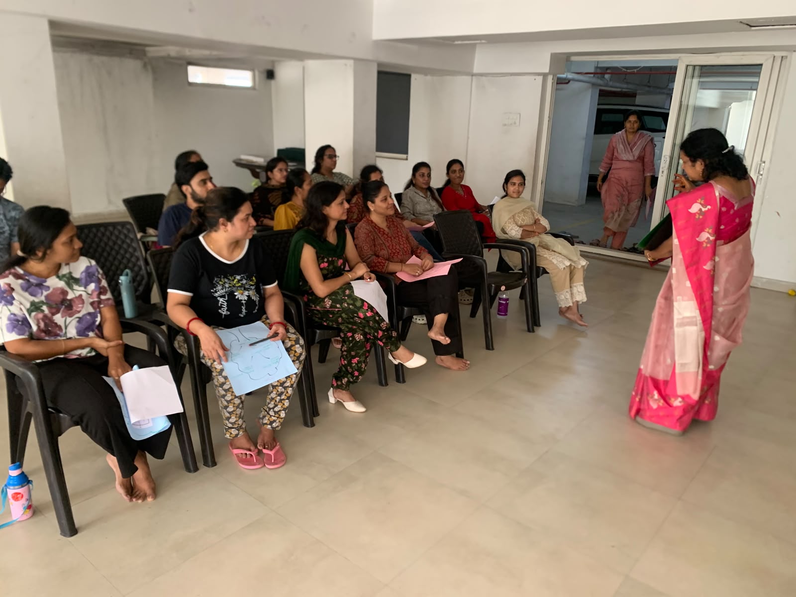 A Jignyasa counselor speaking warmly with a group of parents during a well-being session